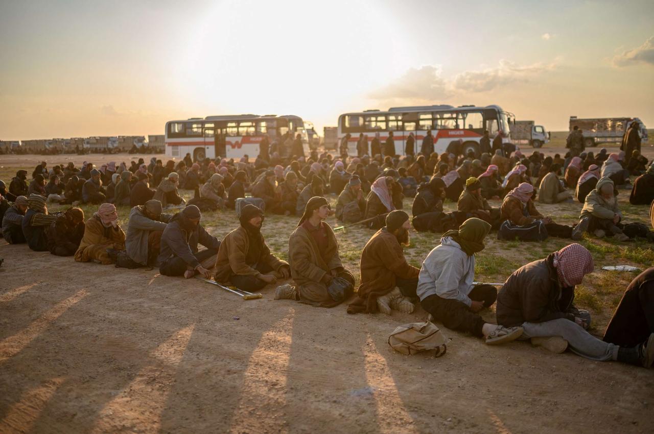 Des hommes soupçonnés d'être des combattants de l'État islamique (EI) attendent d'être fouillés par des membres des Forces démocratiques syriennes (FDS) dans la province de Deir ez-Zor (Syrie), le 22 février 2019. © Bulent KILIC / AFP